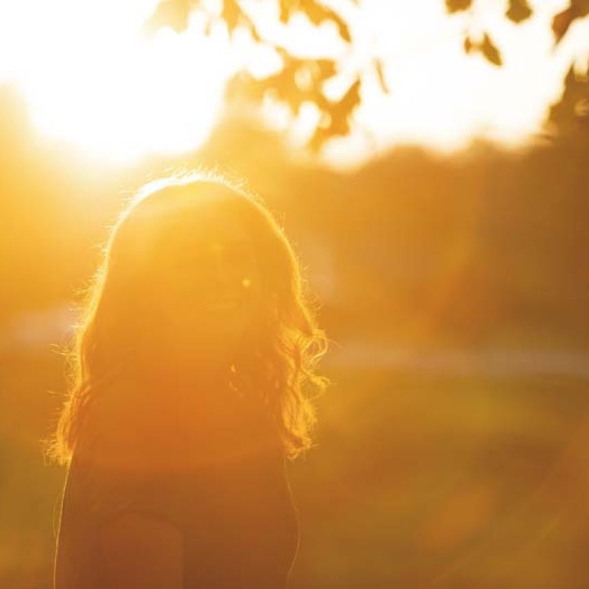student with long hair back lit by sun