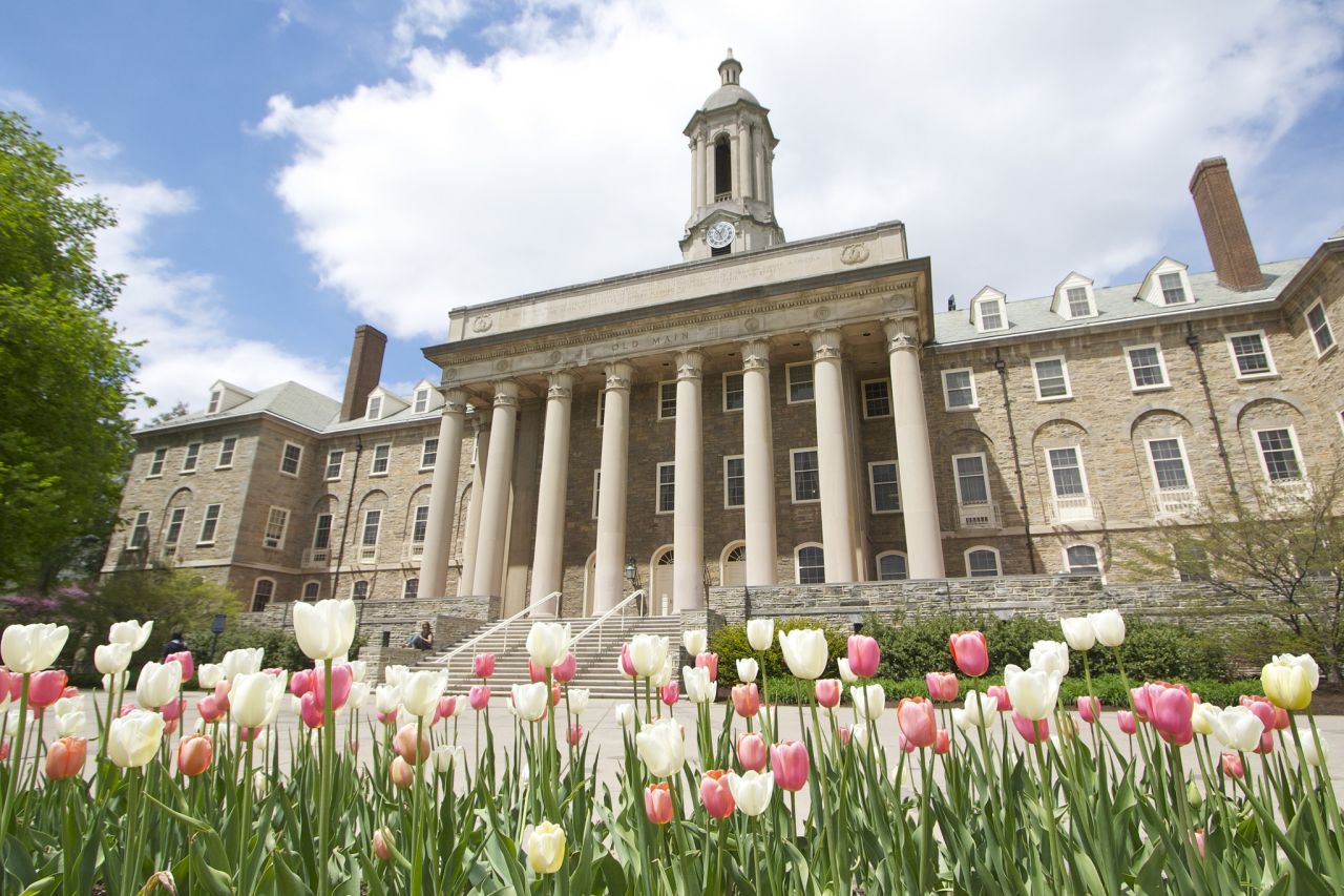 low angle of Old Main with pink and light yellow tulips in foreground